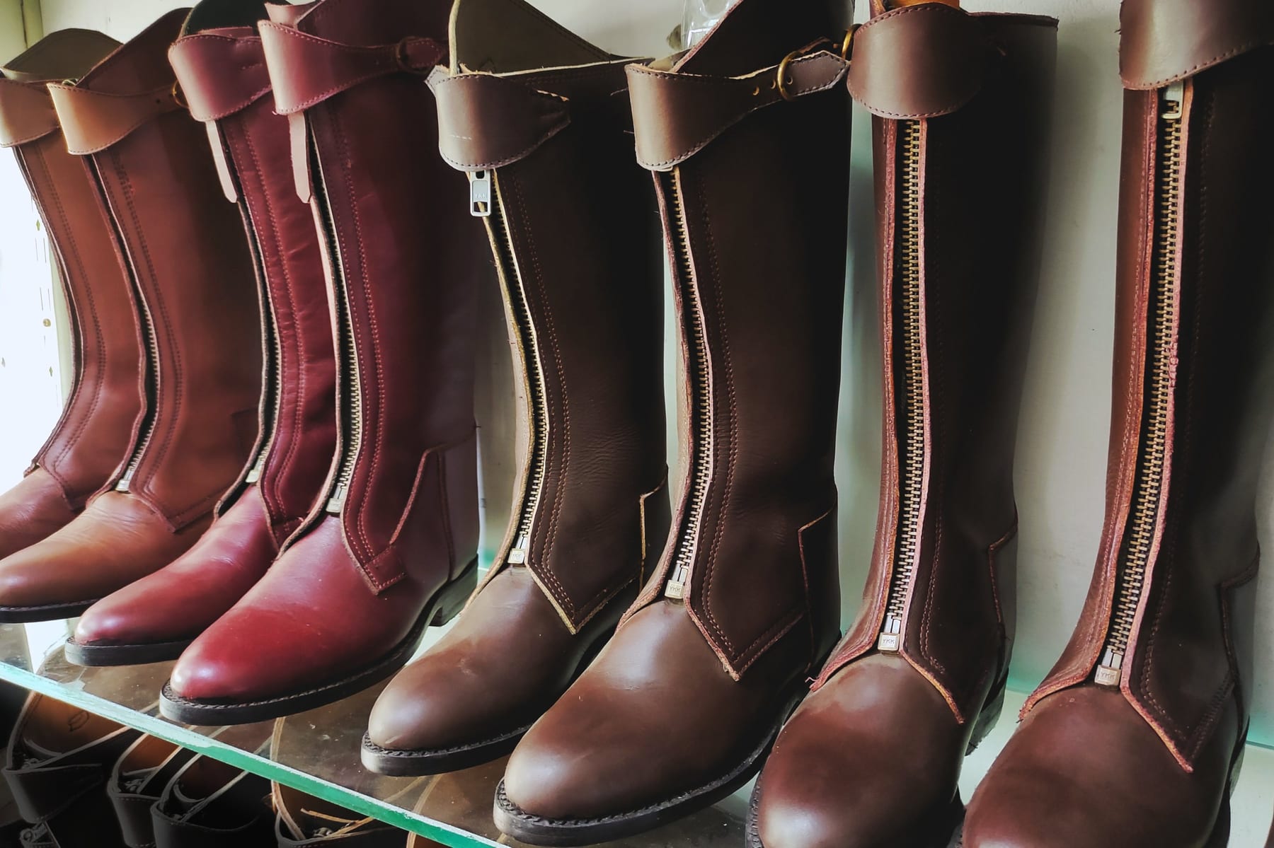 Hand made polo boots on the shelf in the family workshop